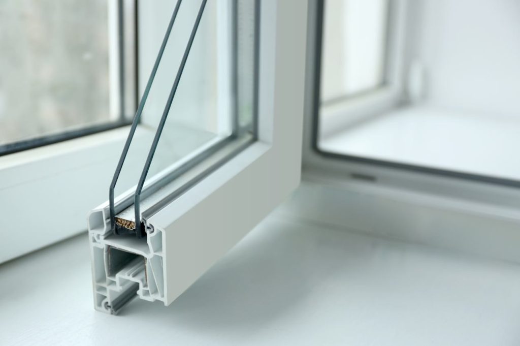 Coupe transversale d'une fenêtre montrant la structure du profilé PVC et du double vitrage, illustrant l'importance d'un bon coefficient isolation thermique menuiserie pvc pour l'efficacité énergétique.